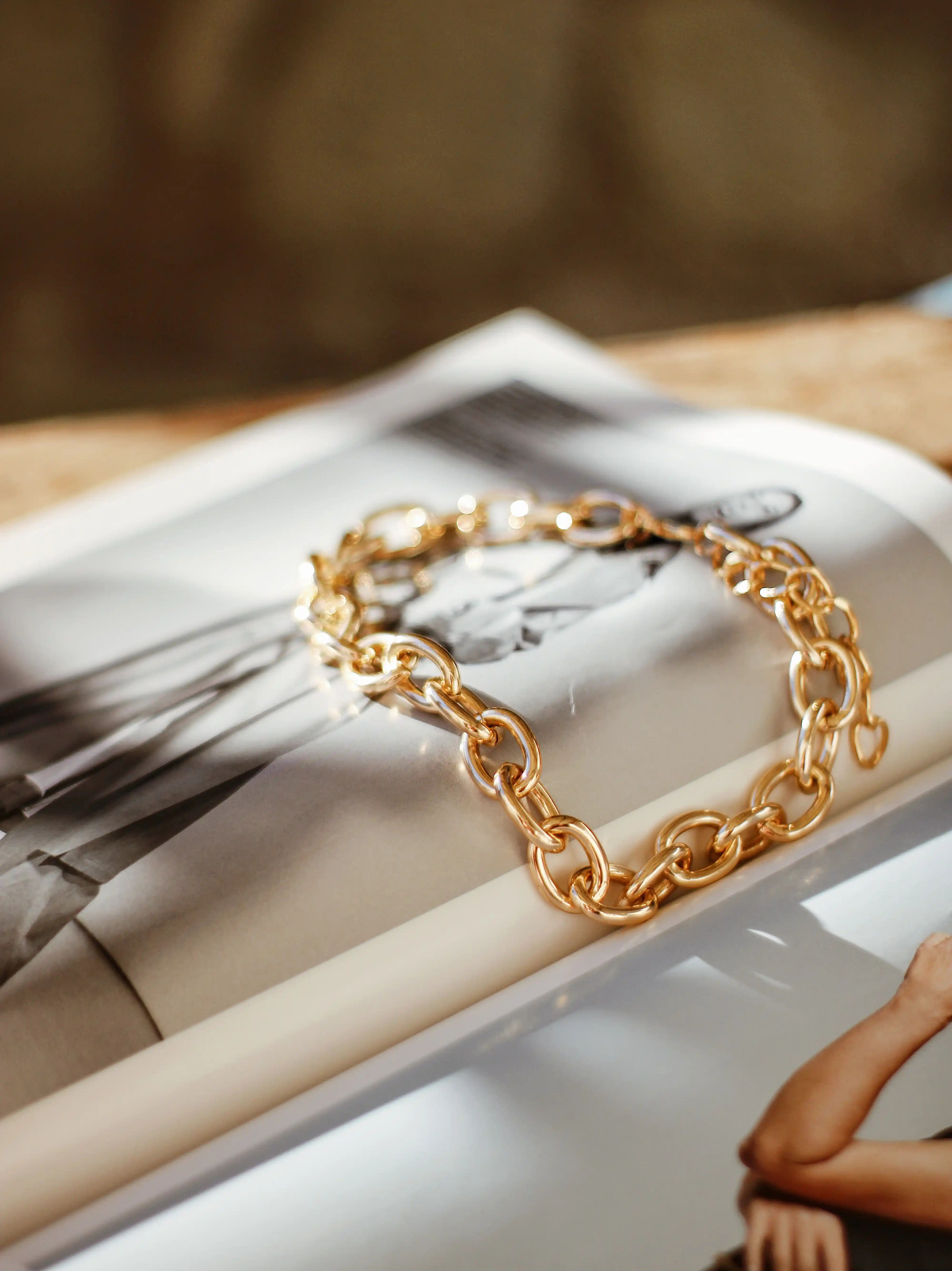 Gold bracelet laid uopn a fashion magazine