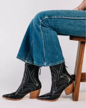 seated person modeling jeans and cowboy boots